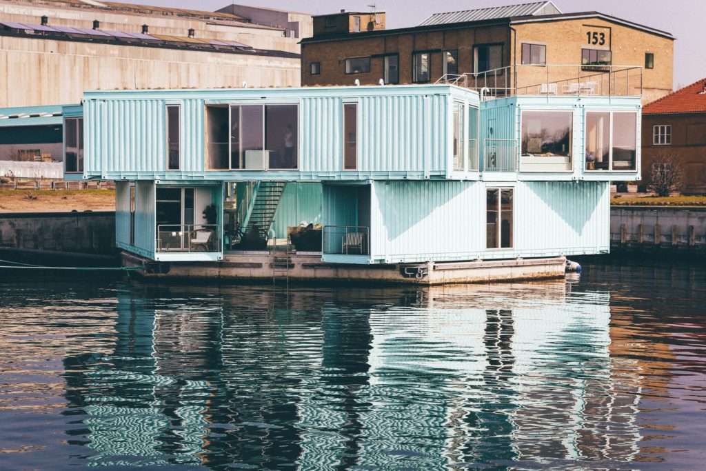 white wooden house near body of water at daytime